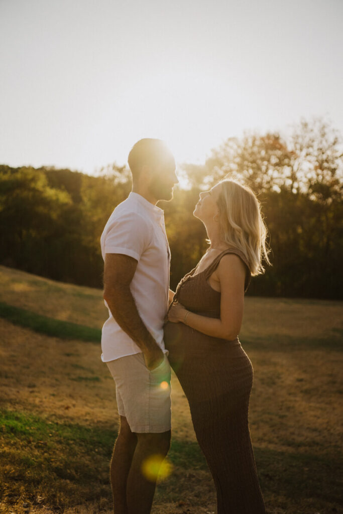 Husband and pregnant wife stand facing each other, smiling as the sun sets through the trees behind them. Maternity session photographed at Zilker Park in Austin.

Zilker Maternity Portraits. Austin Photography. Zilker Maternity Photographer.