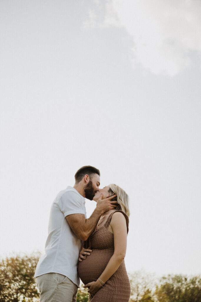 Photographed from a low angle, husband and his pregnant wife kiss. Maternity session photographed at Zilker Park in Austin.

Zilker Maternity Portraits. Austin Photography. Zilker Maternity Photographer.
