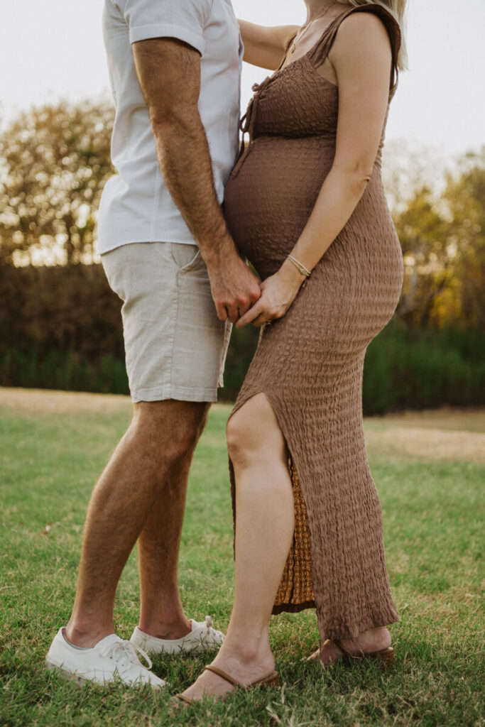Husband and wife stand facing each other holding hands. Photographed from the shoulders down. Maternity session photographed at Zilker Park in Austin.

Zilker Maternity Portraits. Austin Photography. Zilker Maternity Photographer.