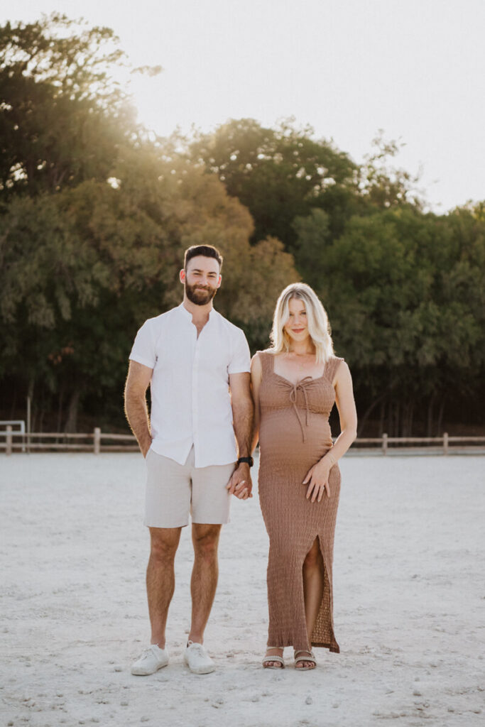 Husband and pregnant wife stand next to each other hand in hand, smiling at the camera. Maternity session photographed at Zilker Park in Austin.

Zilker Maternity Portraits. Austin Photography. Zilker Maternity Photographer.