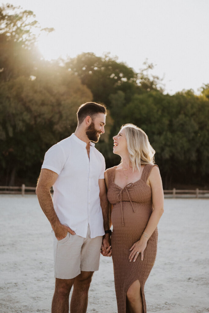Husband and pregnant wife stand next to each other, hand in hand, smiling at each other. Maternity session photographed at Zilker Park in Austin.

Zilker Maternity Portraits. Austin Photography. Zilker Maternity Photographer.