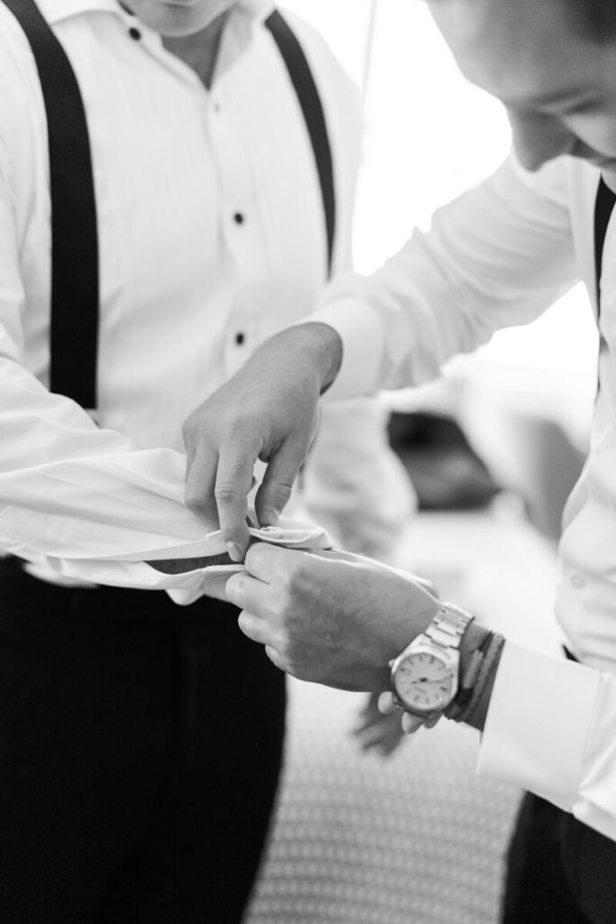 Detail shot of a man's hands helping to button the shirt cuff of the groom. Black and white photograph.

Luxury NYC Wedding Photography. Manhattan Luxury Wedding Photographer. NYC Luxury Wedding. University Club Wedding Photographer.