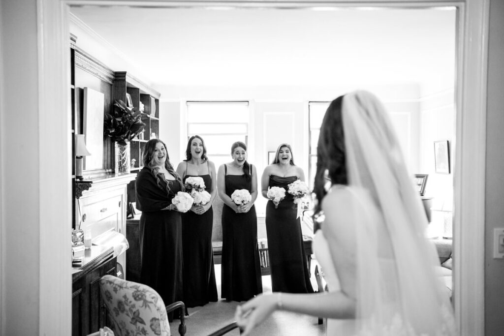 Bride is in the foreground, looking away from the camera. Her bridesmaids are in the background, in focus, with bouquets in their hands and expressions of joy on their faces. Black and white photograph.

Luxury NYC Wedding Photography. Manhattan Luxury Wedding Photographer. NYC Luxury Wedding. University Club Wedding Photographer. Bridal party portraits.