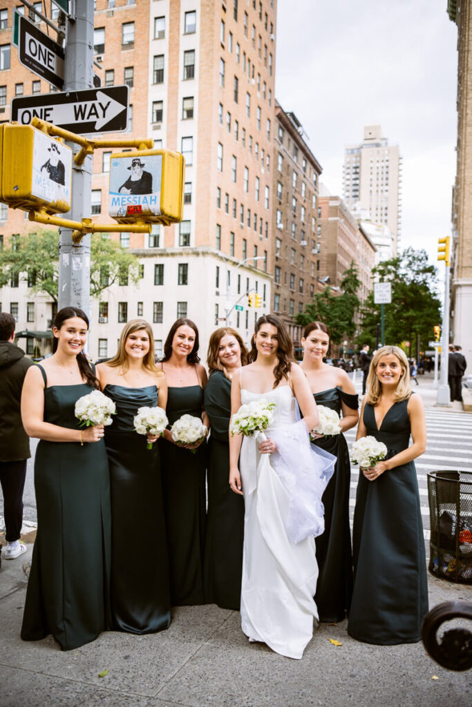 Bride and her bridesmaids are standing next to each other on a street corner in Manhattan, smiling at the camera. Bride is wearing a white wedding gown and bridesmaids are wearing different styles of dresses in a deep navy color.

Luxury NYC Wedding Photography. Manhattan Luxury Wedding Photographer. NYC Luxury Wedding. University Club Wedding Photographer.