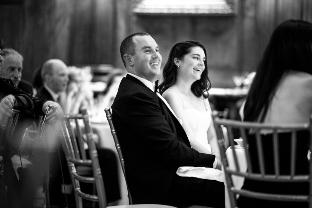 Bride and groom are sitting at a table, surrounded by wedding guests, smiling. Black and white photograph.

Luxury NYC Wedding Photography. Manhattan Luxury Wedding Photographer. NYC Luxury Wedding. University Club Wedding Photographer.