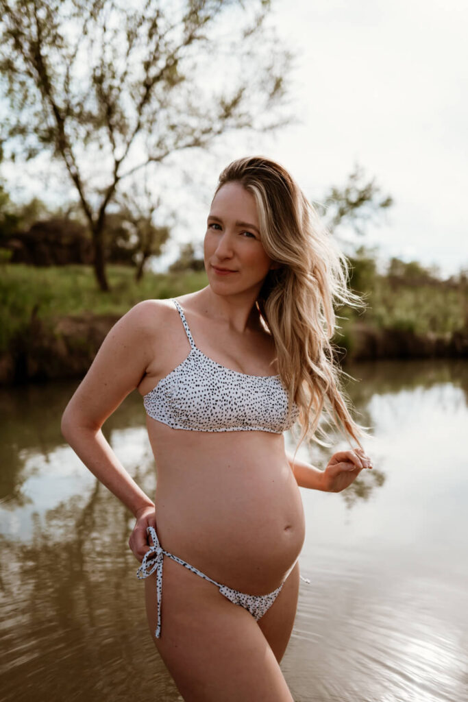 Austin maternity photographer Kat Harris captures pregnant woman in the lake with chic bikini and beach waves.