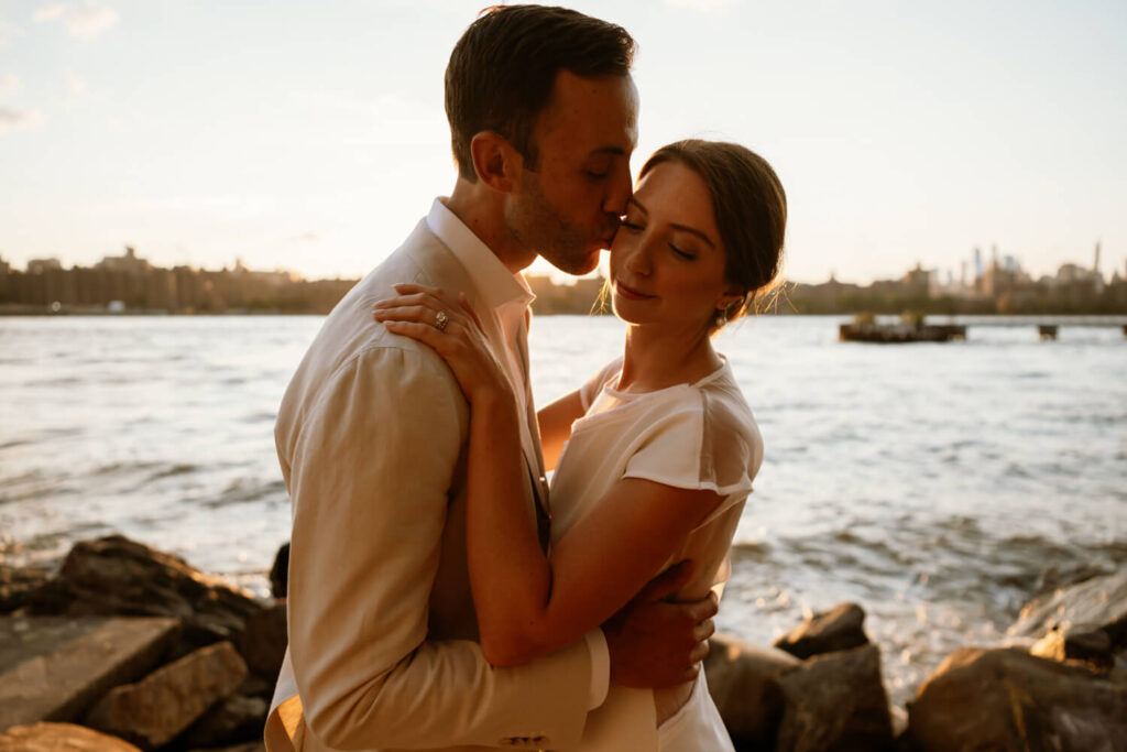 engagement photo shoot at Williamsburg's Domino  park in Brooklyn, NY by Austin photographer Kat Harris featuring woman wearing silk white dress and man wearing black suit. 