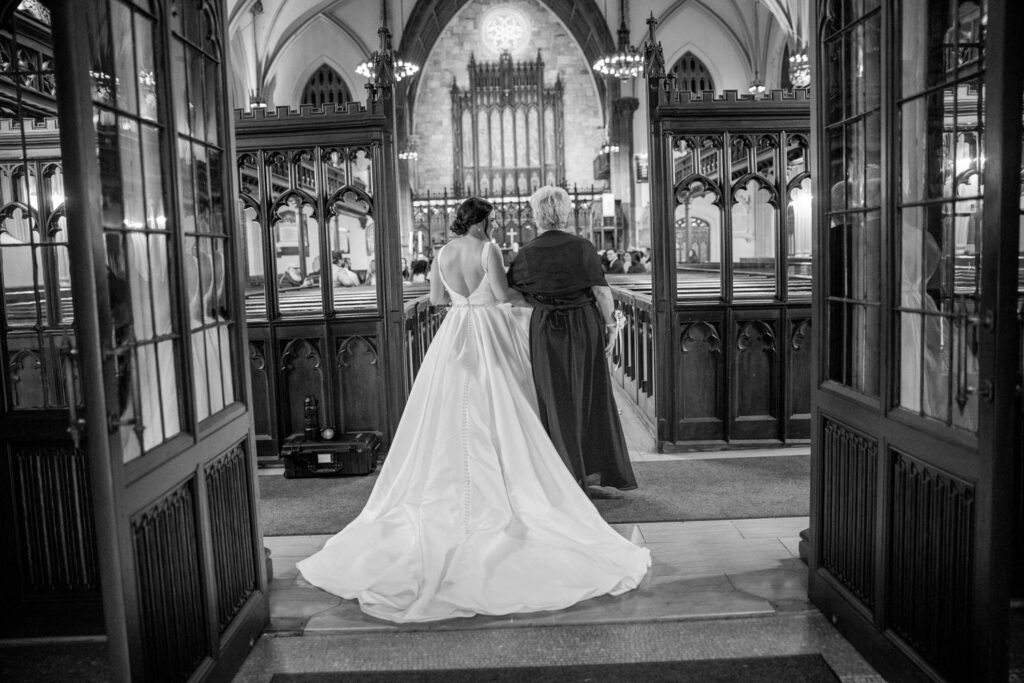 bride and mother of the bride walking down the aisle towards the groom during the wedding ceremony at First Presbyterian Church on 5th ave. and 12th street photographed by New York City wedding photographer Kat Harris.