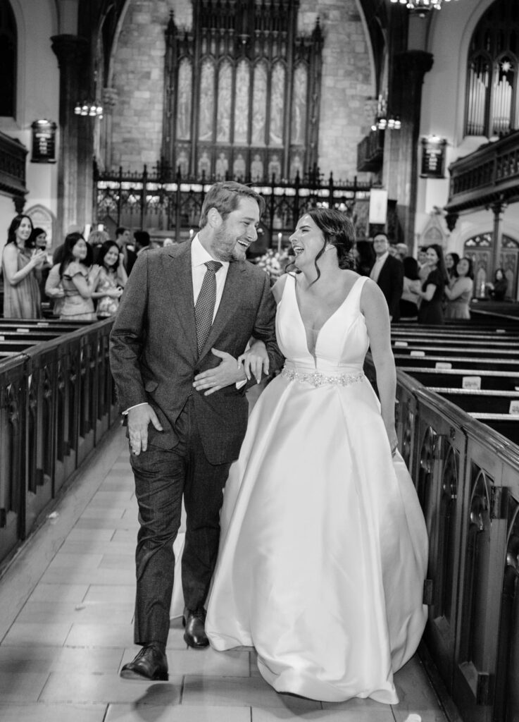 Ecstatic couple leaves their wedding ceremony smiling and laughing as a newly married couple at The First Presbyterian Church on 12th street and 5th ave photographed by New York City wedding photographer Kat Harris.