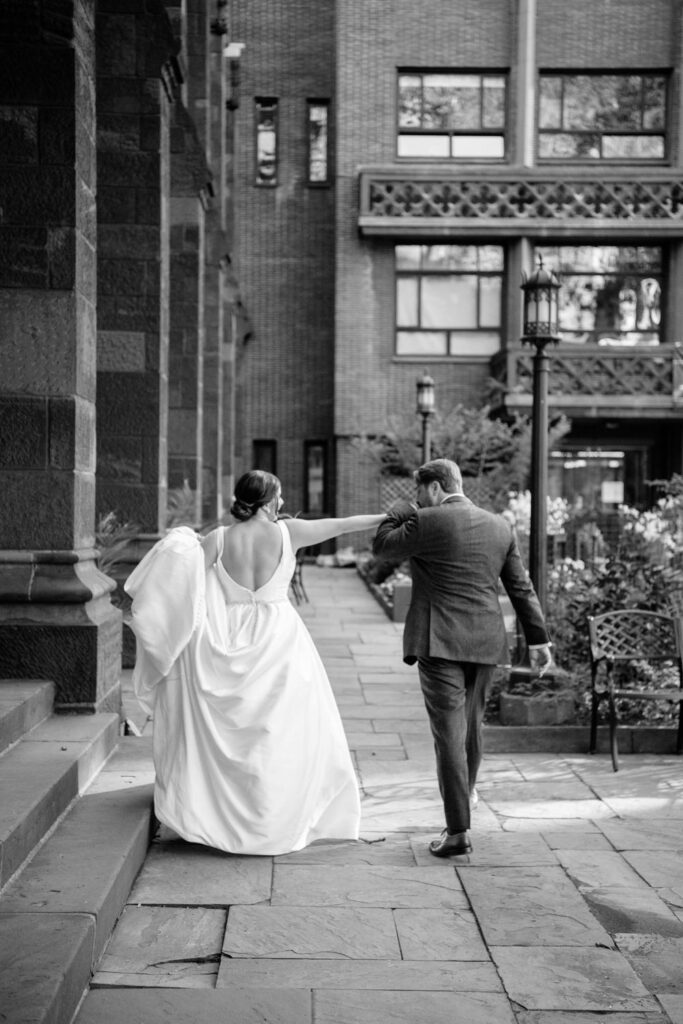 Groom kisses the bride on her hand and share a private moment as they leave their wedding ceremony and walk outside at The First Presbyterian Church on 12th street and 5th ave photographed by New York City wedding photographer Kat Harris.