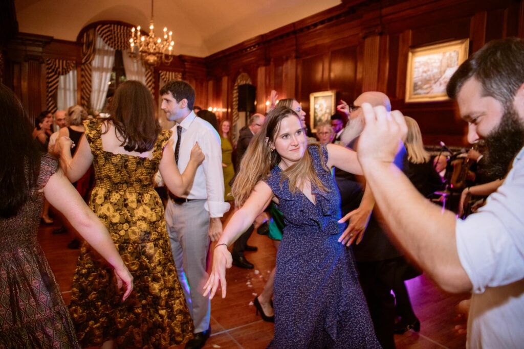 group of people dancing and having a great time on the dance floor during the University Club wedding reception with a live band photographed by New York City wedding photographer Kat Harris.